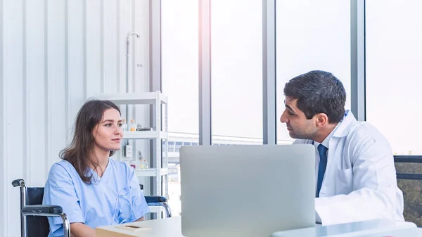 Asian doctor consulting and examining pretty patient for her health in seriously at medical clinic or hospital, seeing doctor concept