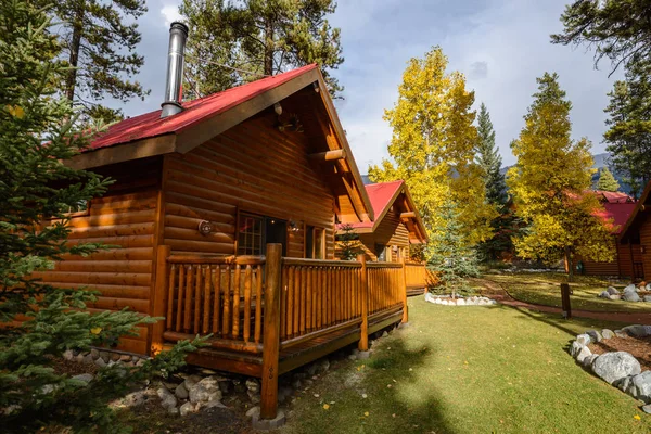 Gemütliches ruhiges Holzhotel am bunten Herbstwald Stockbild