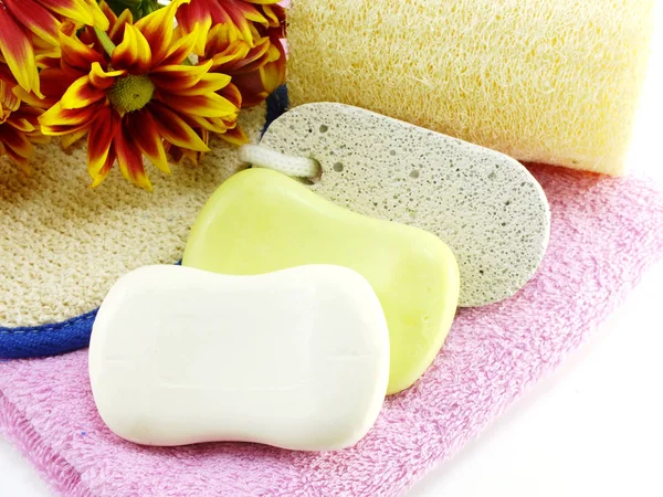 Tvål på vit badhandduk och scrub på vit bakgrund — Stockfoto