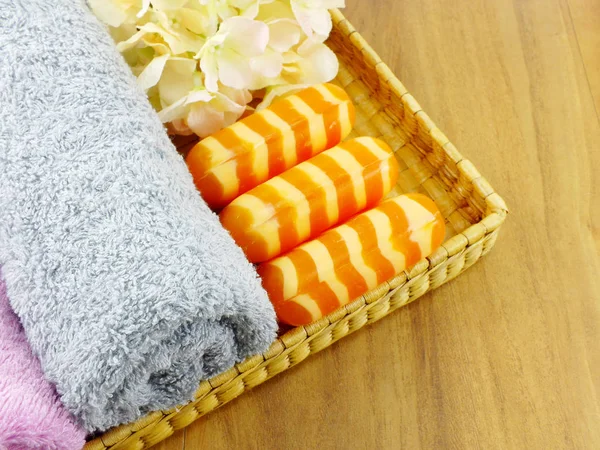 Orange soap with white stripes and towel top view on wooden background — Stock Photo, Image