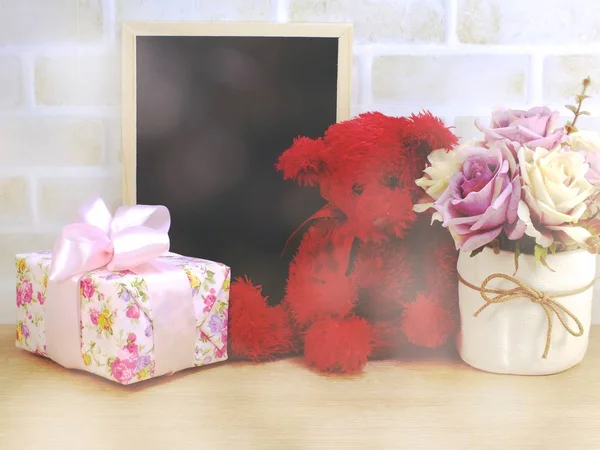cute teddy bear doll with gift box and flowers with copy space