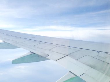 Bulutlar ve gökyüzü bir uçağın penceresinden görüldüğü gibi