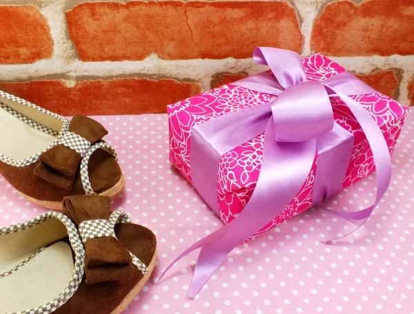 Розовая коробка подарка и женская обувь на розовом фоне горошек точка — стоковое фото