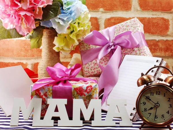 Bos bloemen met een geschenk doos en word mama op houten achtergrond — Stockfoto