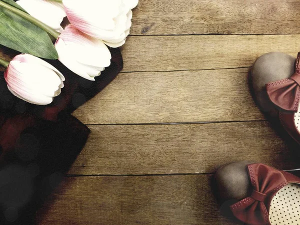 Kadın Ayakkabı ve çiçek buketi ahşap arka plan üzerinde daireler