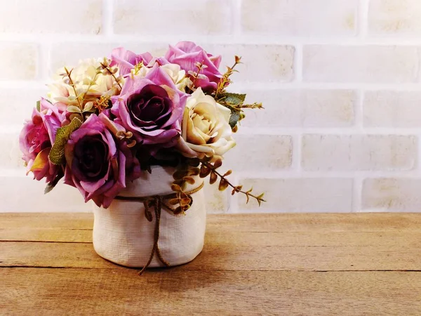 Flores artificiais rosa em vaso no papel de parede de madeira e espaço — Fotografia de Stock