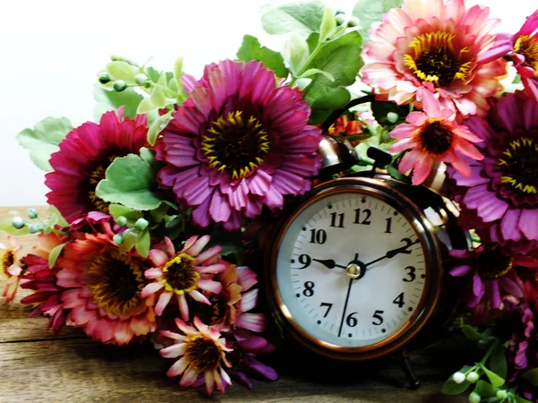 Wiosną czas z budzikiem i sztuczne kwiaty bukiet tło — Zdjęcie stockowe