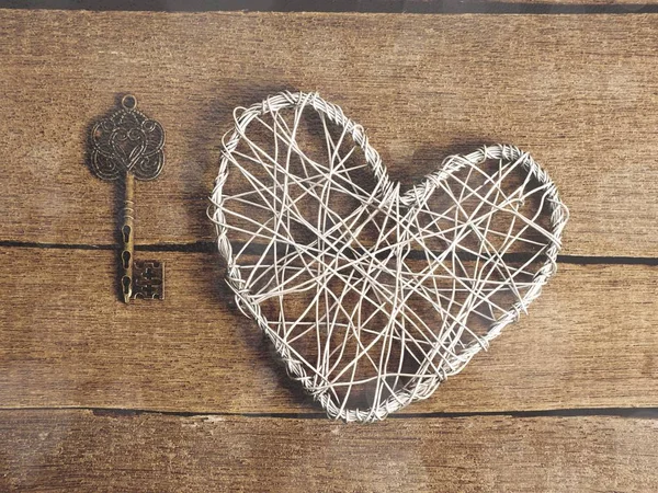 photo retro key and heart shape on wooden background
