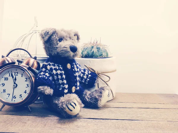 Brown teddy bear sitting on wooden table with cactus in small pot and space copy — Stock Photo, Image