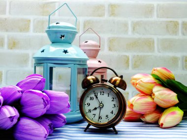 Fener ve yapay çiçek buketi ev dekorasyon konsepti ile çalar saat