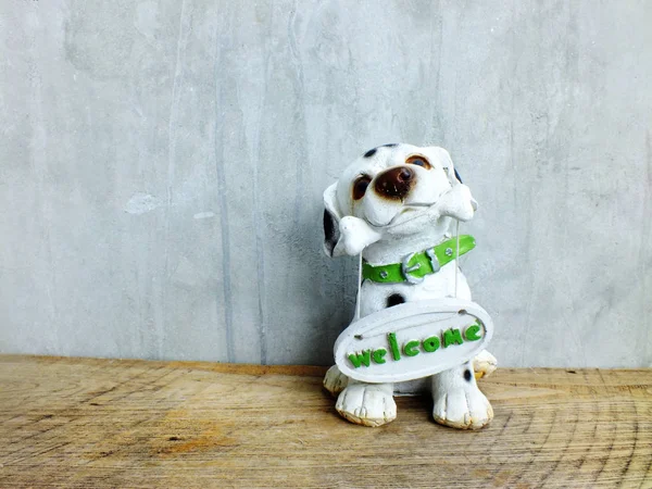 Keramische hond met Welkom bord op houten achtergrond — Stockfoto