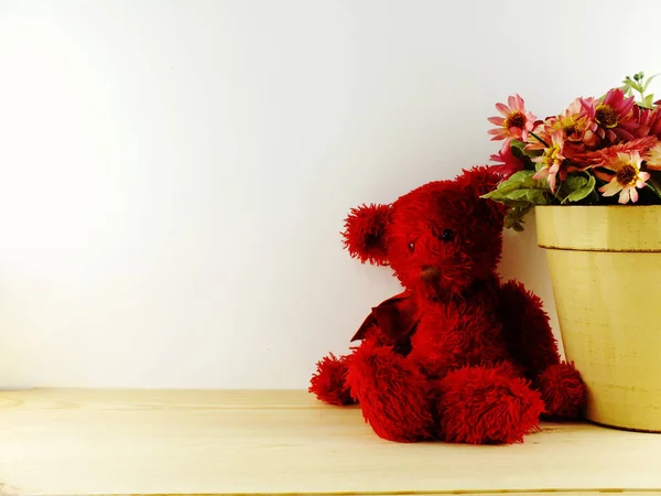 Ведмедик з будильником і букетом квітів на дерев'яному фоні — стокове фото