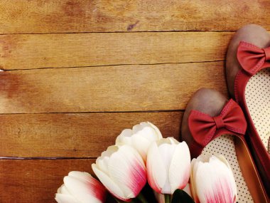 Kadın Ayakkabı ve çiçek buketi ahşap arka plan üzerinde daireler
