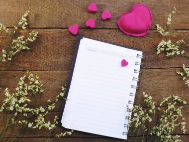 boş defter ile kalpleri ve kuru çiçekler üstten görünüm ahşap dokular üzerinde