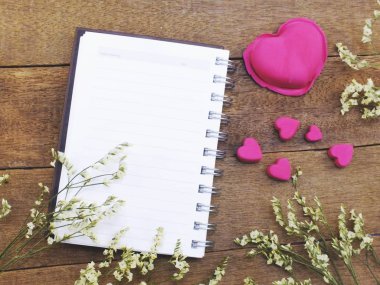 boş defter ile kalpleri ve kuru çiçekler üstten görünüm ahşap dokular üzerinde