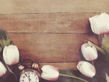 güzel ahşap zemin üzerine lale buketi ile çalar saat