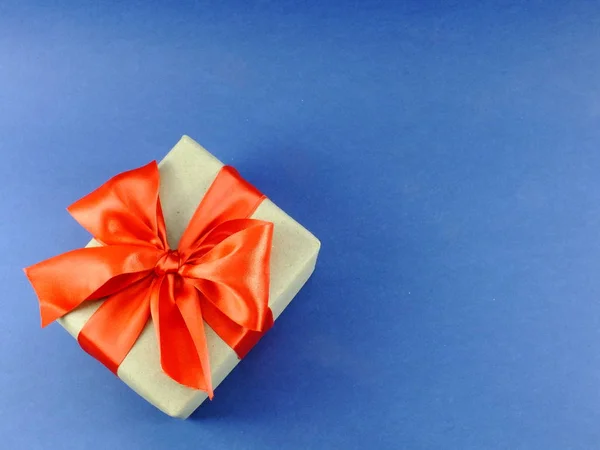 蓝色背景下带蝴蝶结的再生纸包装礼品盒 — 图库照片