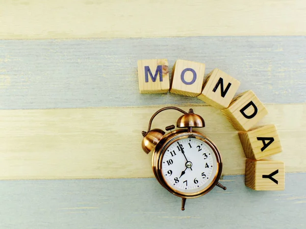 Pazartesi küp ahşap blok ve çalar saat üst görünümden alan arka plan ile