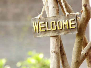 hoş geldiniz işareti bahçede asılı