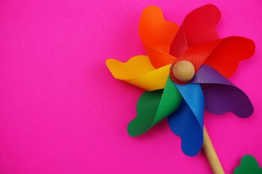 Pembe arka plan üzerinde izole edilmiş boşluk kopyasına sahip renkli fırıldak