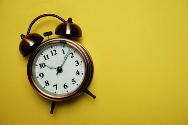 Sarı arkaplanda boşluk kopyası olan klasik alarm saati