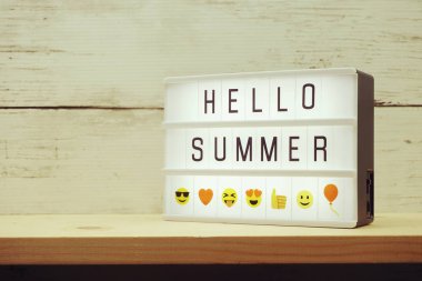 Merhaba. Ahşap zemin üzerinde ışık kutusunda yaz metni.