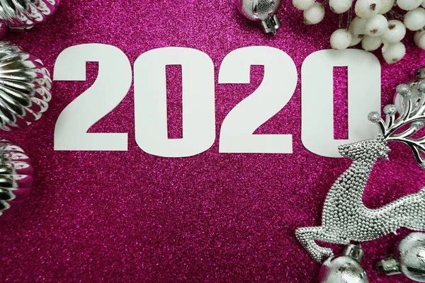2020 happy new year with star berry and reindeer decoration on pink glitter background