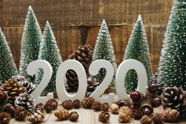 Yeni yılınız kutlu olsun. Ahşap arka planda Noel ağacı ve çam kozalağı süslemesi var.