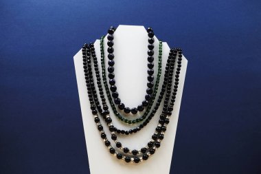 Mavi arkaplanda boşluk kopyasıyla ayakta duran İnci Kolye