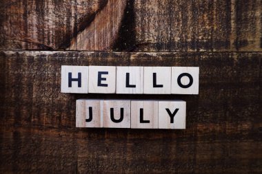 Ahşap arka plan üzerinde boşluk kopyası ile Happy July alfabe mektubu