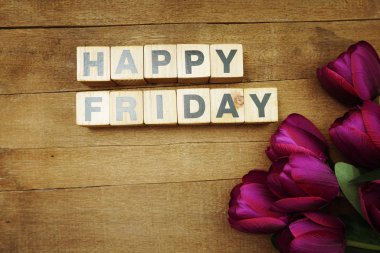 Ahşap zemin üzerinde lale çiçeği olan mutlu Cuma alfabesi mektupları