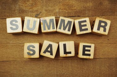 Tahta zemin üzerinde boşluk kopyası olan yaz indirimi alfabesi harfi