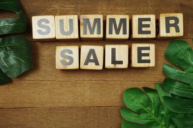 Tahta zemin üzerinde boşluk kopyası olan yaz indirimi alfabesi harfi