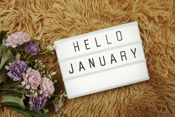 Hello January word in light box and flower bouquet
