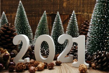 Yeni yılınız kutlu olsun. Ahşap zemin üzerinde Noel ağacı ve çam kozalağı süslemesi olan şenlikli bir geçmiş.
