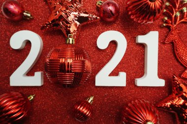 2021 with christmas ball decoration Flat lay on red glitter background