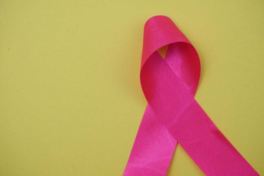 Sarı arka planda pembe kurdele göğüs kanseri farkındalığı