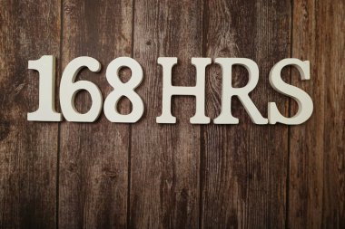 168 Saat Bir haftada ahşap arka planda uzay kopyası ile saat sayısı
