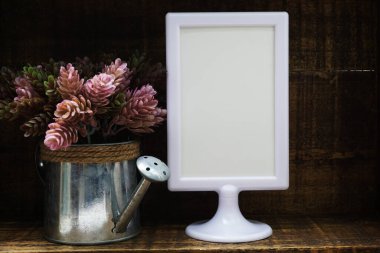Boş ekran çerçeve standı ve ahşap arka planda yapay bitki ev dekorasyonu