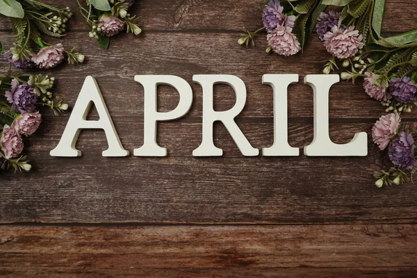 木製の背景に花の装飾が施された4月のアルファベット — ストック写真