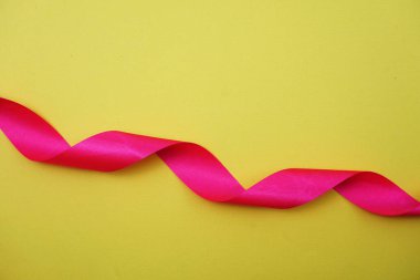 Sarı arkaplanda spiral pembe kurdele