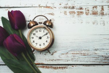 Klasik Alarm Saati ve ahşap arka planda uzay kopyası olan Lale Buketi