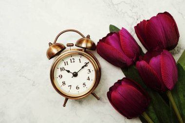 Antika Alarm Saati ve mermer arka planda uzay kopyası olan Lale Buketi