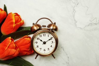 Antika Alarm Saati ve mermer arka planda uzay kopyası olan Lale Buketi