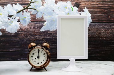 Boş çerçeve standını ve alarm saatini tahta arkaplanda göster