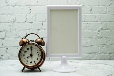 Boş çerçeve standını ve alarm saatini tahta arkaplanda göster.