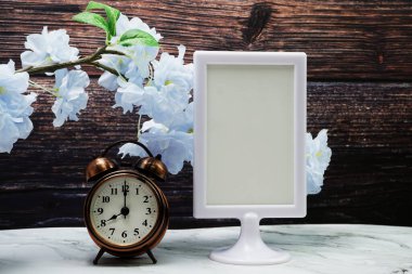 Boş çerçeve standını ve alarm saatini tahta arkaplanda göster