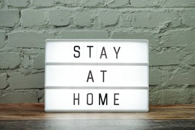 Beyaz tuğladan duvar arkaplanındaki ışık kutusunda Ev Kelimesi Mektubunda kal