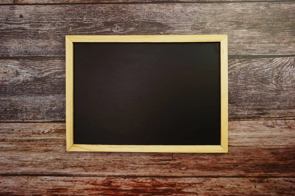 暗い木製の壁のテクスチャの背景に空の黒いボード — ストック写真