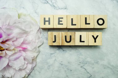 Mermer zemin üzerinde pembe çiçek desenli Temmuz alfabesi harfleri.